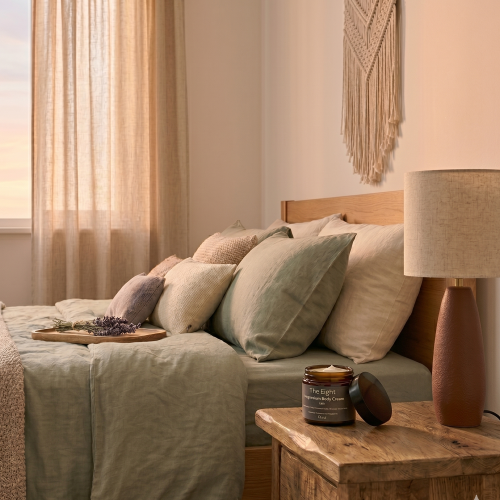 Cozy bedroom with a bed, lamp, and decorative items.